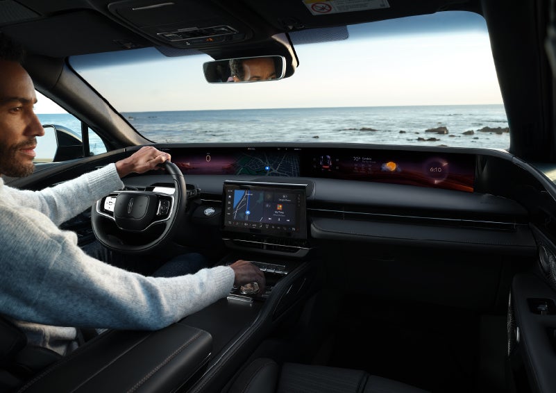 A driver of a parked 2024 Lincoln Nautilus® SUV takes a relaxing moment at a seaside overlook while inside his Nautilus. | Empire Lincoln of Huntington in Huntington NY